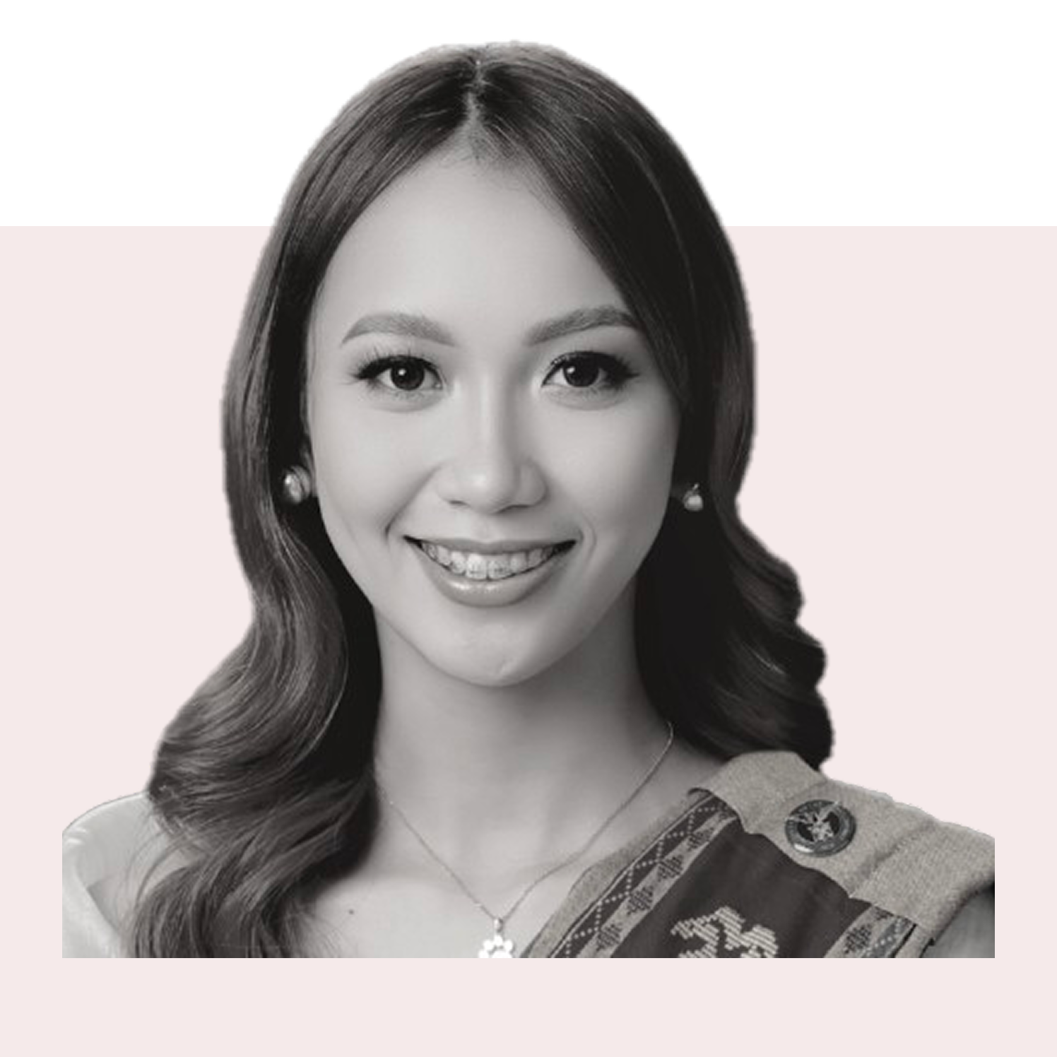 Black and white portrait of a smiling woman with wavy hair and jewelry with a sash